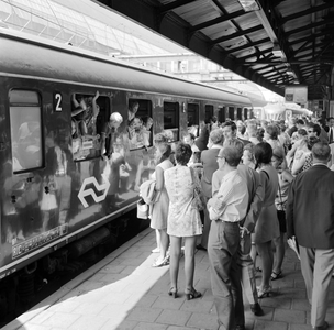 883125 Afbeelding van drukte op het vierde perron van het N.S.-station Amsterdam C.S. te Amsterdam, met een groep ...